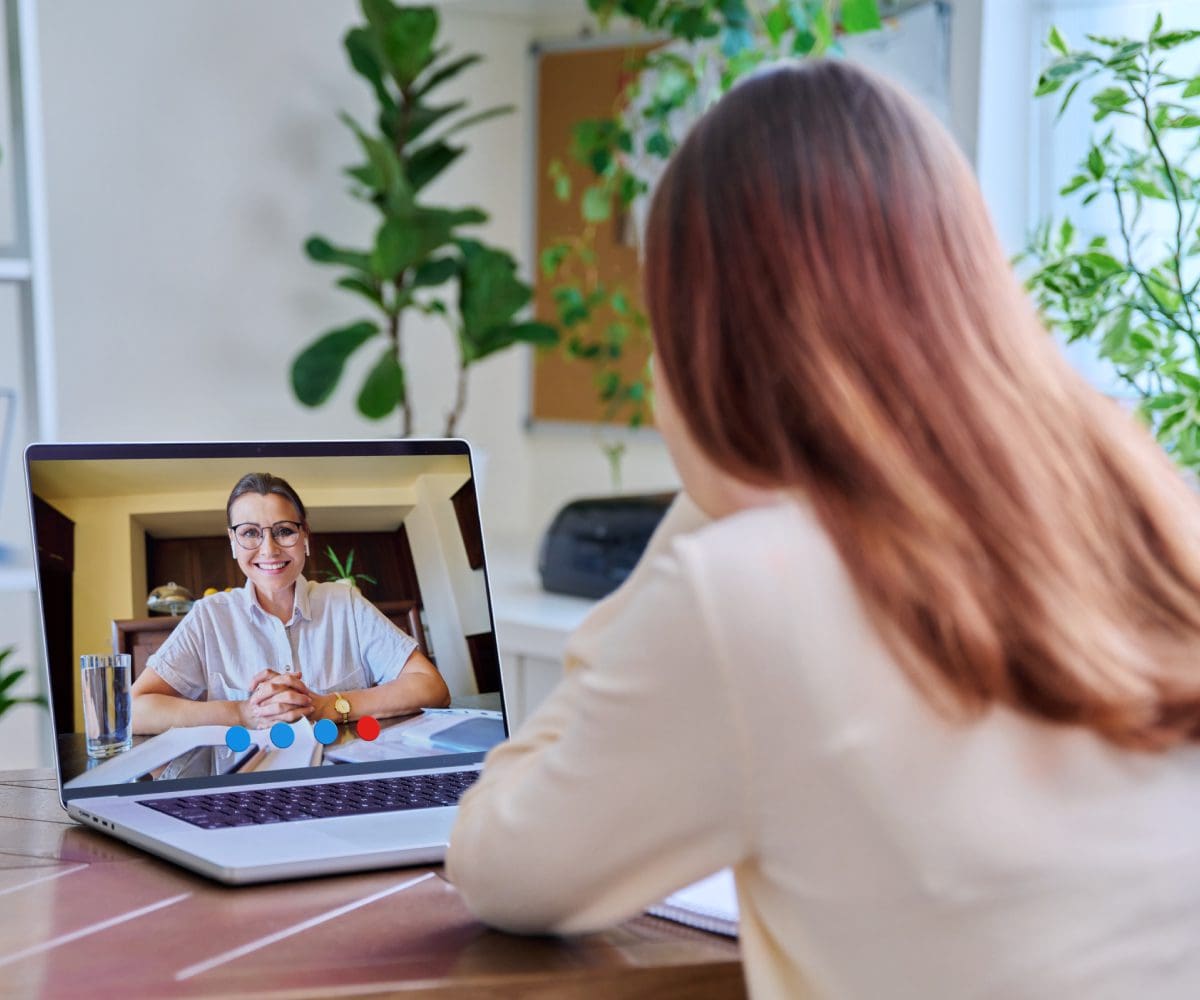 Woman video conferencing with a man on a laptop.