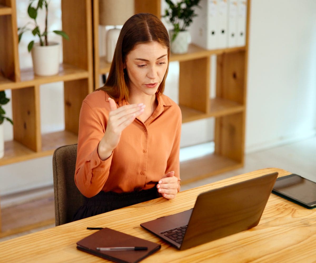 A woman is working intently on her laptop in a cozy office space.